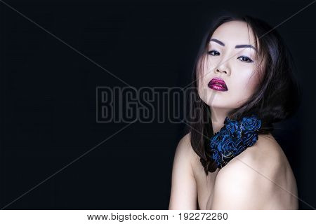 Portrait of the beautiful asian girl with creative art makeup on black background