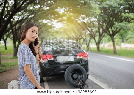 Asian woman using mobile phone while looking and Stressed woman after broken down car on street