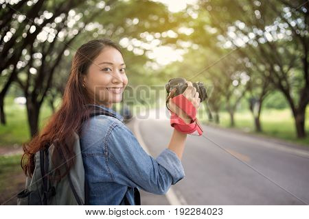 Women photographer holding a camera in the wild for take a photo of the tourist traveler