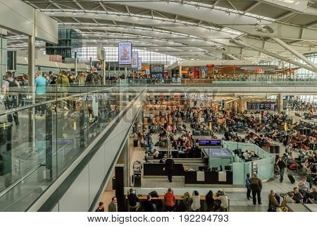 LONDON UK - MARCH 7 2017: Heathrow Airport Terminal 5 passengers waiting to get gate information mid-morning.
