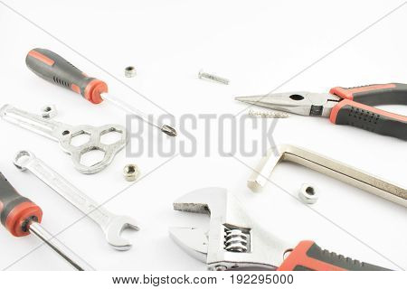 Screwdrivers wrenches tweezers with nuts and bolts.