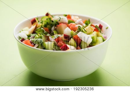 Indian Green Salad also known as Kachumber is a colourful salad dish in Indian cuisine consisting of fresh chopped tomatoes, cucumbers, onions, and sometimes, chili peppers. selective focus