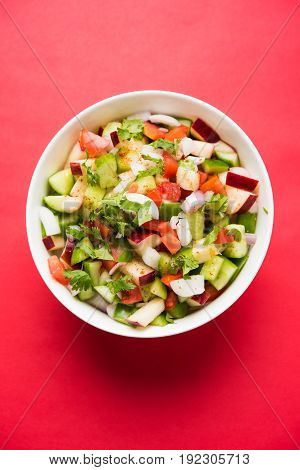 Indian Green Salad also known as Kachumber is a colourful salad dish in Indian cuisine consisting of fresh chopped tomatoes, cucumbers, onions, and sometimes, chili peppers. selective focus