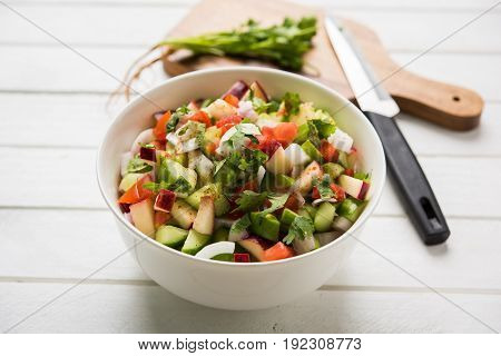 Indian Green Salad also known as Kachumber is a colourful salad dish in Indian cuisine consisting of fresh chopped tomatoes, cucumbers, onions, and sometimes, chili peppers. selective focus