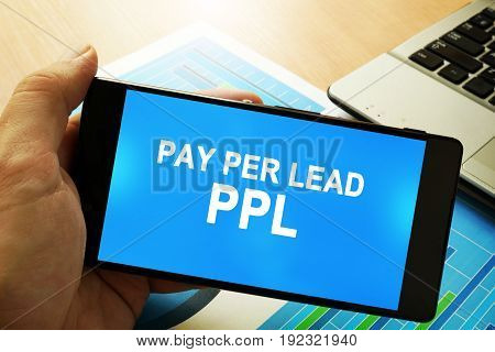 Hand holding smartphone with words Pay per lead PPL.