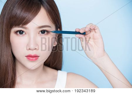 beauty woman woman take eyeliner on the blue background