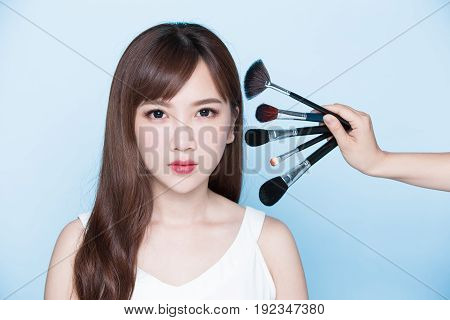beauty woman take makeup brush on the blue background