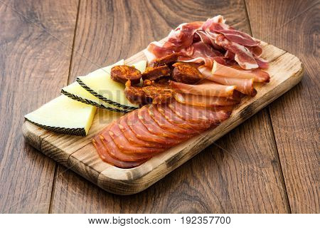 Spanish cold cuts (embutidos). Cheese, sausage and ham on wooden table