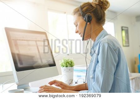 Customer service operator talking on phone in office