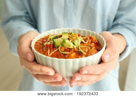 Woman holding bowl with delicious chili turkey, closeup