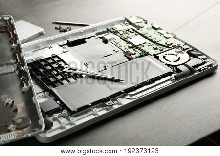 Dismantled laptop with tools on table. Concept of computer repair