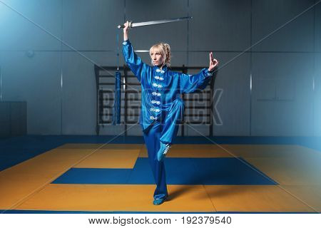 Female wushu fighter with sword in action
