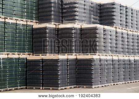 Several stacks of colorful beverage bottle crates outdoors.