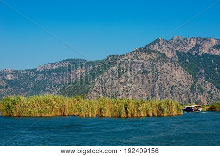 TURKEY, MUGLA , DALYAN. The Dalyan River with tourist boat in the straits of the river