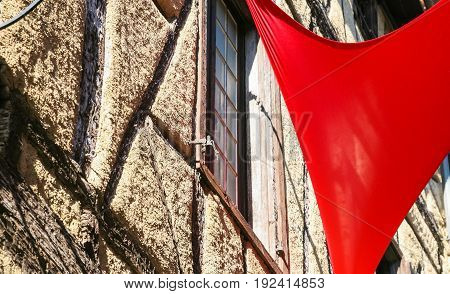 Flag And Wall Of Old House In Medieval Town