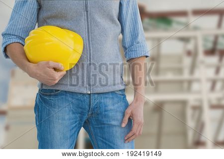 Digital composite of Worker holding a yellow helmet against construction