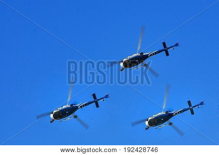 three civilian helicopter in the blue sky.