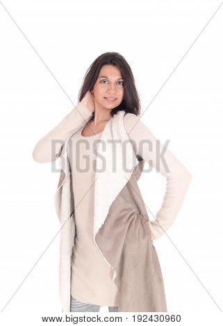 A young Hispanic woman standing the front in a deerskin coat with one hand on her head isolated for white background.
