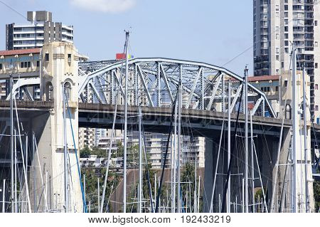 The view of Burrard Bridge through yacht masts in the city of Vancouver (British Columbia).