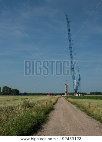 building a new wind power plant with a big blue crane Kalkar Germany