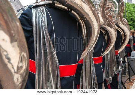 Details from a music show and marching band. Playing musicians wind instruments in uniforms. Tuba Sousa