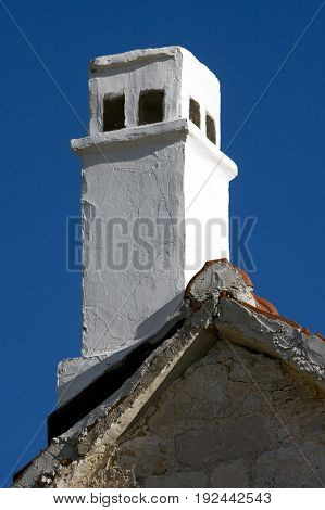White painted chimney on old mediterranean stone house in Croatia on island Brac