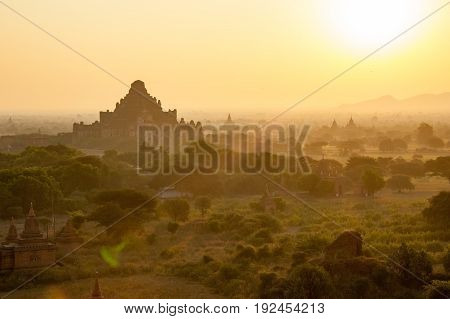 Beautiful ancient pagoda field in sun rise with fog and haze
