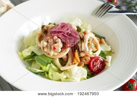 Salad with iceberg lettuce seafood and marinated red onion.