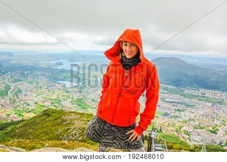 Happy tourist after hiking on Mount Ulriken. Norwegian tourism highlight. Bergen city skyline in Norway. Traveler woman in North Europe. Scenic norwegian landscape and popular landmark.