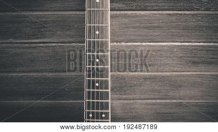 ooden guitar. Close-up of guitar lying on vintage wood background