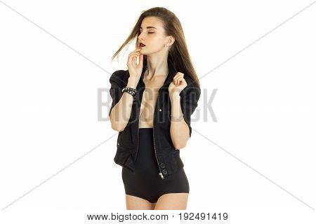 Sensual young woman in black jacket and high panties with closed eyes isolated on white background