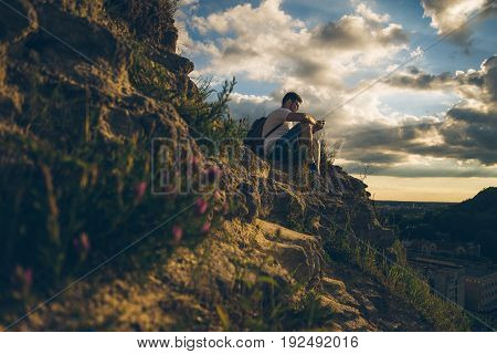 blured blooming flowers in the mountains with young man on background