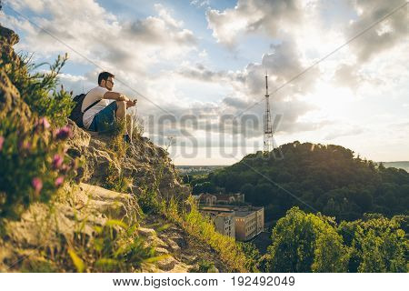 blured blooming flowers in the mountains with young man on background