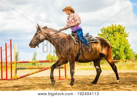 Cowgirl In Western Hat Doing Horse Jumping