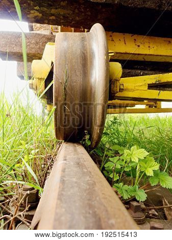 Cargo Wagon Wheel Stay On Rusty Railway. Old Railway Wagon Wait In Depot. Fresh Green Gras