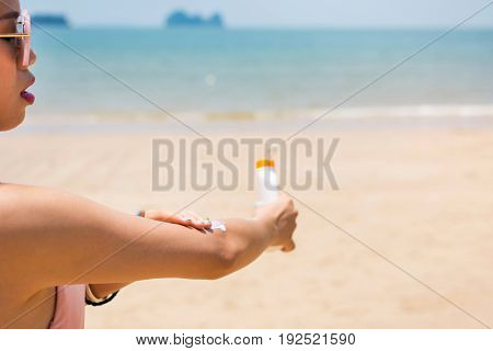 Girl Applying Sun Lotion On The Beach
