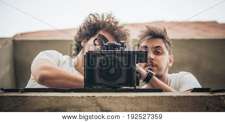 Behind The Scene. Cameraman And Assistant Shooting Film With Camera