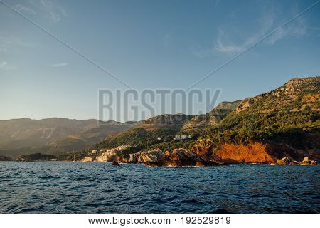 Rocky coast of the Adriatic Sea in Montenegro at sunset, view from the sea