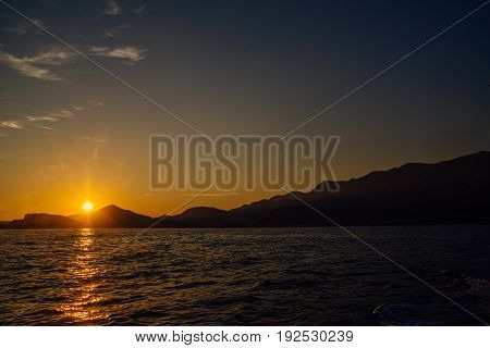 Coast of Montenegro at sunset, view from the sea, silhouettes of mountains