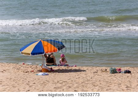 ALVOR, PORTUGAL - APRIL 23, 2017: People at the famous beach of Praia do Alvor, Algarve region, Portugal