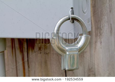 Silver clamp style lock on an electrical box