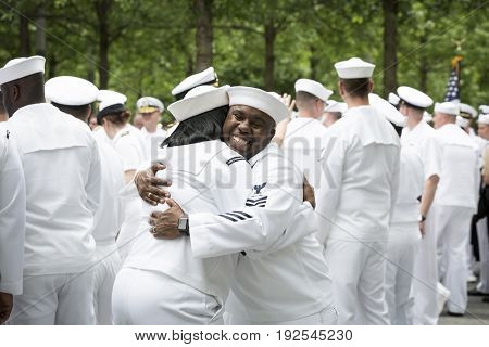 Participating U.S. Navy sailors hug and congratulate each other after the re-enlistment and promotion ceremony at the National September 11 Memorial site. Fleet Week, NEW YORK MAY 26 2017