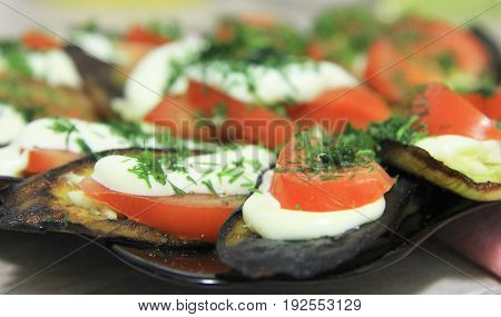 Fried eggplants and fresh tomato with souce and herbs