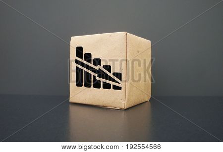 On a dark background a box. It shows the graph going down. Business graph falls.