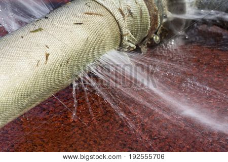 water leaking from hole in a hose.