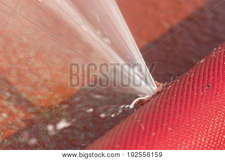 water leaking from hole in a hose.