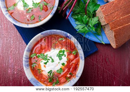 Ukrainian Traditional Borsch. Russian Vegetarian Red Soup  In Blue Bowl On Red Wooden Background.  B