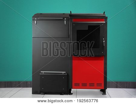 Energy savings concept. Solid fuel boiler on color wall background