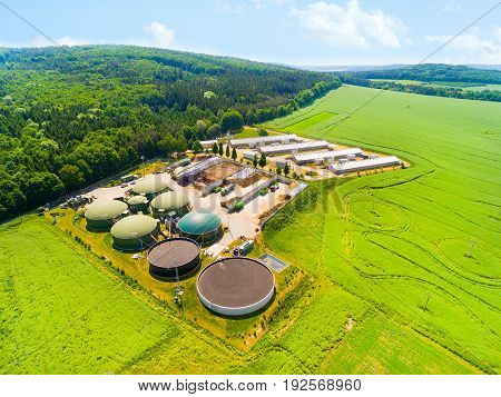 Aerial view over biogas plant and farm in green fields. Renewable energy from biomass. Modern agriculture in Czech Republic and European Union. 