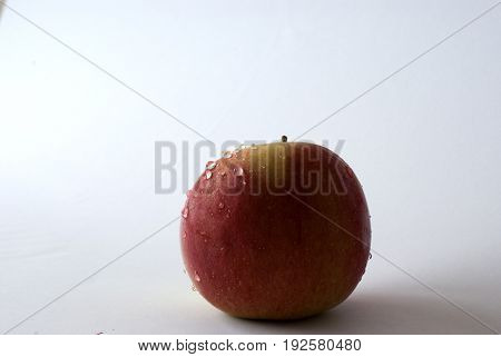 Ripped apple with waterdrops in a white background